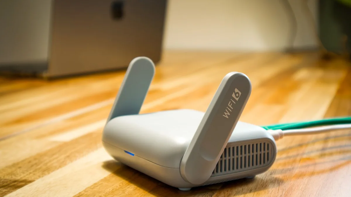 Router de wifi sobre un escritorio de madera en una habitación de casa