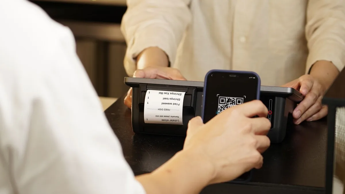 Persona escaneando con el teléfono móvil un código QR de una factura